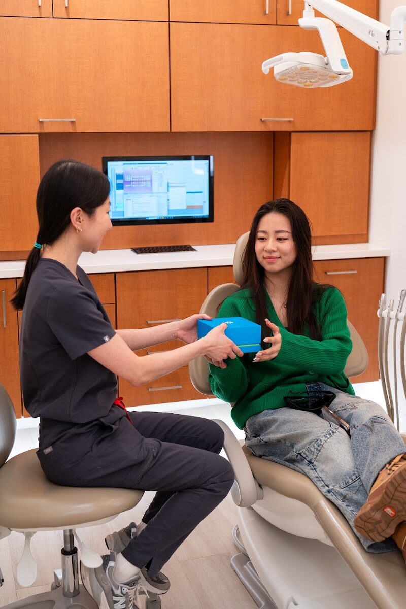 Smiling patient receiving her Invisalign clear aligners at Kingsview Dental